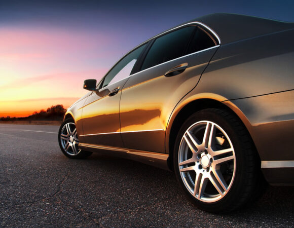Gold car riding on road with sunset with the Cheapest Auto Insurance in Columbus, IN
