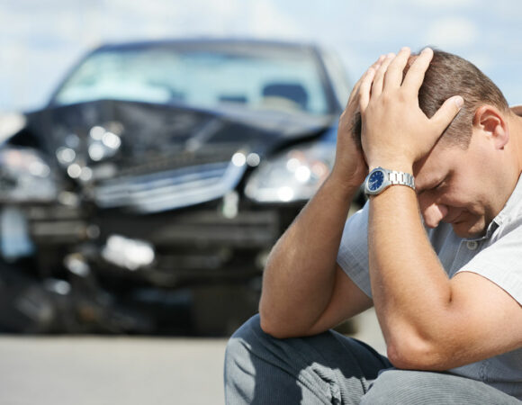 Man with Hands on Head in Front of Crashed Car Needing Auto Insurance in Seymour, IN