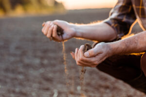 Man Holding Dirt with Agribusiness Insurance in Columbus, IN