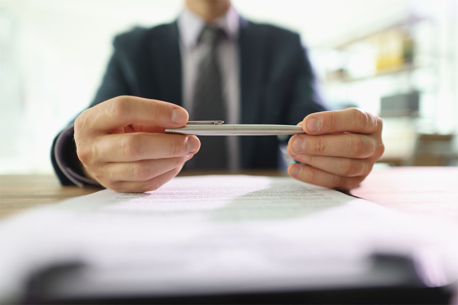 man looking at pen with Business Insurance in North Vernon, Columbus, Madison, Seymour, Greensburg, and Versailles, IN