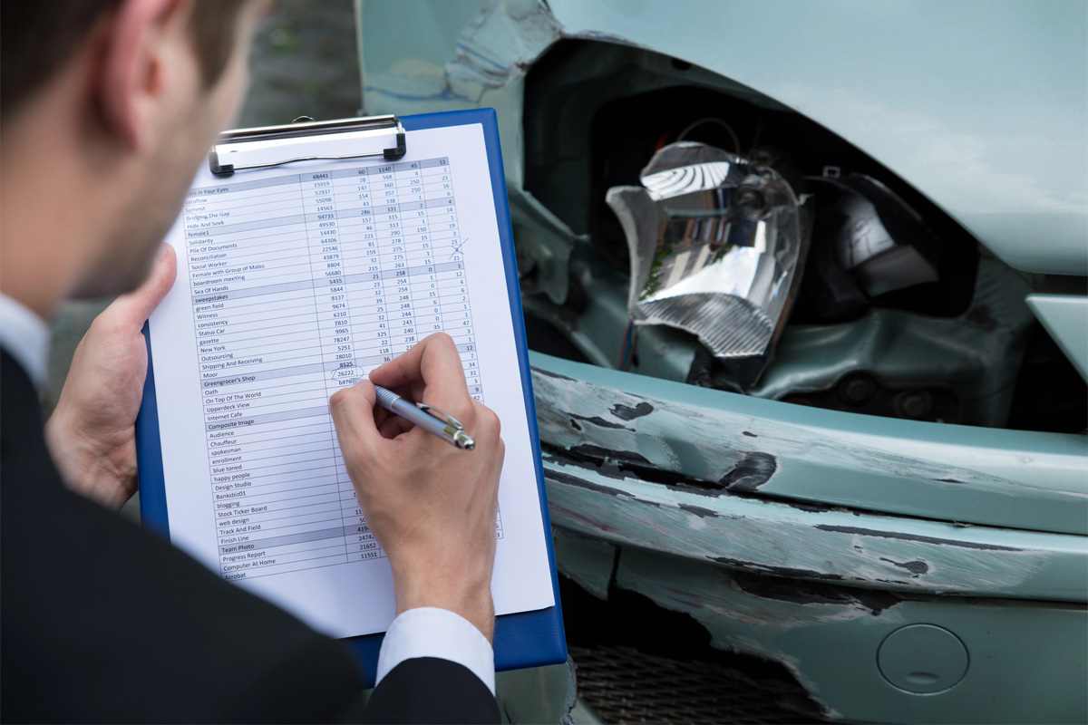 insurance adjuster checking damage with Affordable Car Insurance in Columbus, IN